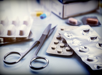 Scissors next to several blister cut, conceptual image