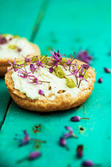 Open faced sandwiches with edible flowers. Top view, blank space