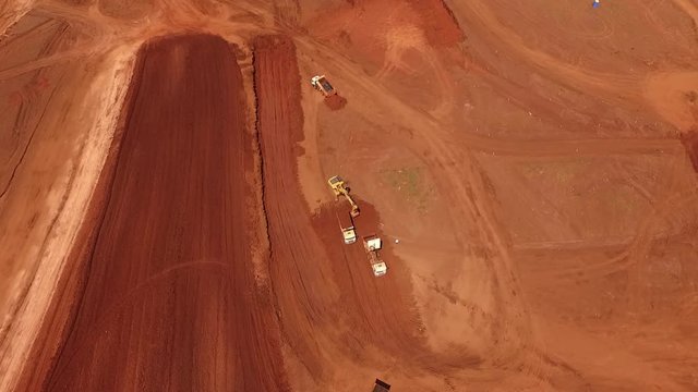 Aerial view, performed by drone, of earthworks in lateritic land area destined for industrial waste plant. One observes the movement of earth and the action of the heavy machines.
