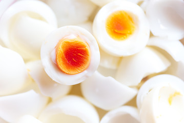 Hard boiled eggs, sliced in halves on white background