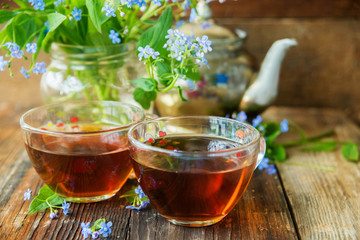 Romantic background with cup of tea ,lilac flowers and open book over white table