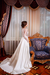 Fototapeta premium The beautiful young woman posing in a wedding dress