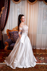 Fototapeta premium The beautiful young woman posing in a wedding dress