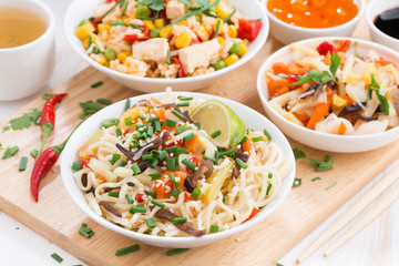 lunch -noodles with vegetables and greens, fried rice with tofu on wooden board