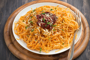 Italian pasta with tomato sauce and cheese on dark wooden background, close-up