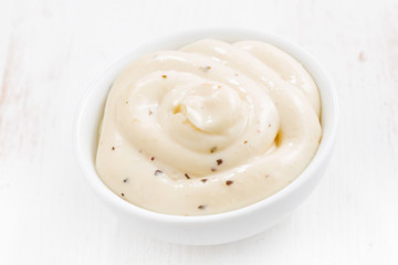 mayonnaise with herbs in a bowl, top view