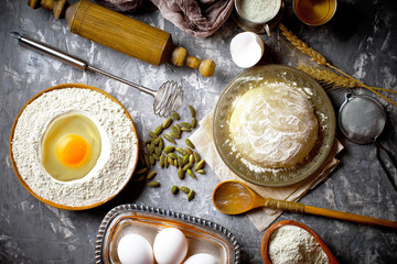 Dough with flour on an old background in a composition with kitchen accessories