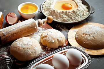 Dough with flour on an old background in a composition with kitchen accessories