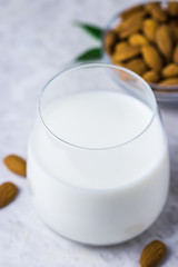 Vegan dairy free almond milk and almonds on white marble background. Selective focus, space for text.
