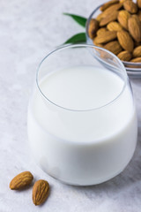 Homemade nut milk and almonds on white marble background. Selective focus, space for text.