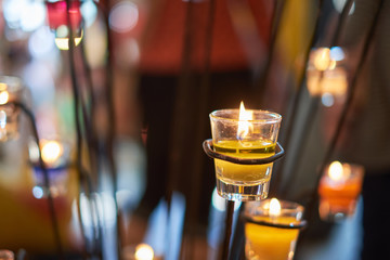 Yellow candle in the glass and bokeh background. subject is blurred.