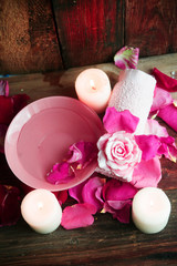 Spa settings with roses. Fresh roses and rose petals in a bowl of water and various items used in spa treatments