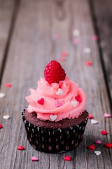 Chocolate cupcakes with pink cream, sugar hearts and fresh raspberries for  Valentine Day