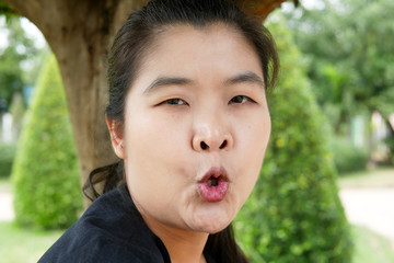 Young Asian Woman Pucker Up Her Lips in a Public Park