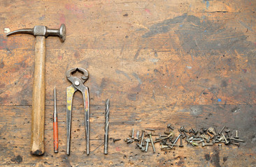 Old used dirty workbench with tools for background.