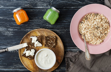 Breakfast muesli, juice, yogurt, crackers with cheese, on a wooden background. Top view.