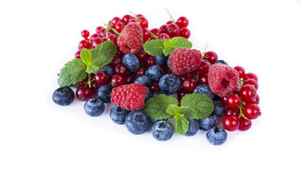 Ripe blueberries, red currants, raspberries with mint isolated on a white. Berries with copy space for text. Red and blue berries. Various fresh summer berries on white background.