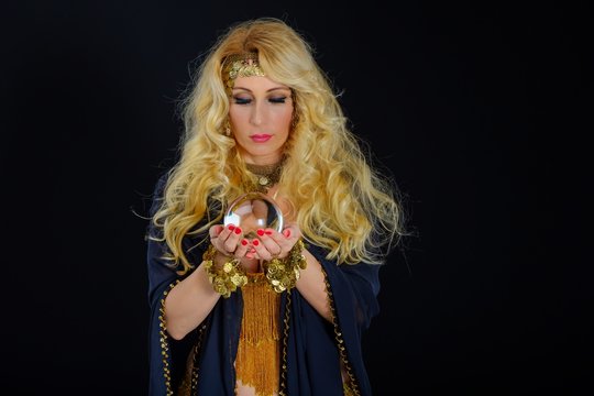 Woman fortune teller with crystal ball portrait on black