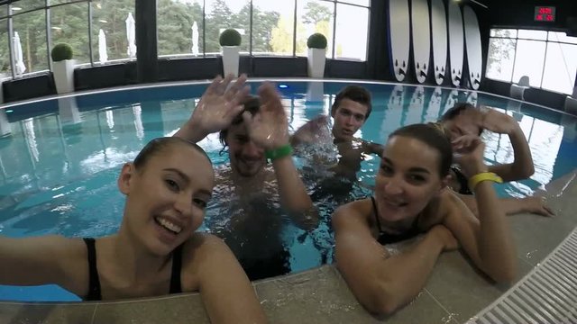 Group of friends swims together in the pool
