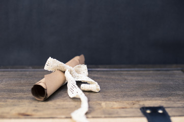 Scrolled brown papyrus with a beautiful ribbon for valentine message with simple black background