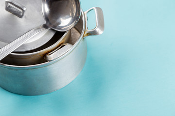 Used home saucepan with scratches on blue paper background