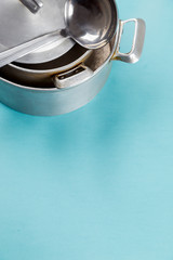 Used home saucepan with scratches on blue paper background