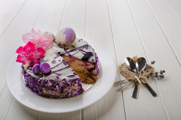 Homemade blueberry cheesecake decorated flower and macaroon on wooden white table background. Top view.