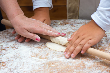 Obraz na płótnie Canvas Girl rolling dough with rolling pin