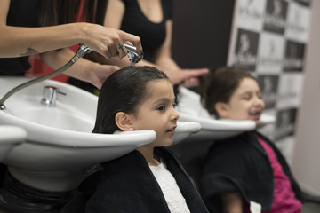 Hairdressers with little girls, cleaning headsg