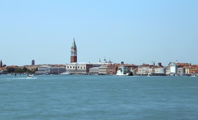 Fototapeta premium View of the island of venice with ancient palaces and bell towers with long exposure time and the wake of the movement of ships on the Venetian lagoon