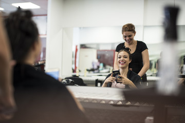 Hairdresser cuts and comb young womans hair