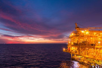 Offshore oil and gas rig platform with beautiful sunset time or twilight time in the gulf of Thailand for business industrial concept