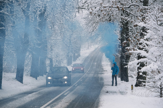 Person with blue bengal on the winter snowy road