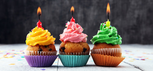 Tasty cupcakes on wooden background. Birthday cupcake in rainbow colors