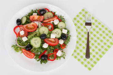 Traditional greek sallad with black olive on white plate on white background.