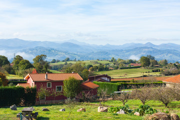 Fototapeta na wymiar Pastoral landscape of Escamplero village with mountains in the background. Asturias, Spain
