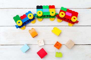 A toy train of cubes of blocks and wooden blocks on a wooden background. Educational toys