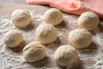 Fototapeta na wymiar fresh raw dough balls on table