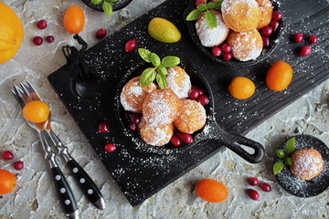 Homemade little donuts of sweet cottage cheese in a cast iron skillet