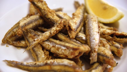 Leckere, knusprig frittierte Sardellen mit Zitrone auf einem Teller
