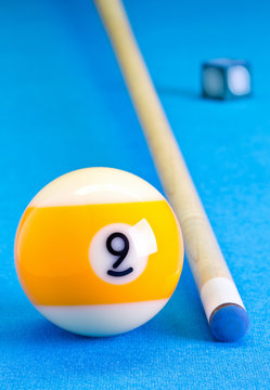 Billiard pool game nine ball with chalk and cue on billiard table