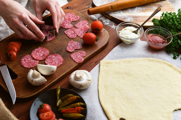 the chef makes a pizza heart for the Valentine's Day holiday. classic Italian pizza with salami and mozzarella