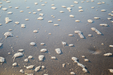 Texture of coastal sand and foam