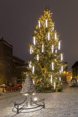 Christmas Tree of Riga, Latvia with illuminated House of Blackheads and St Peter church against the dark blue night sky.