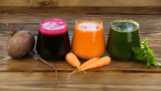 three vegetable juice in glass cup on wooden background