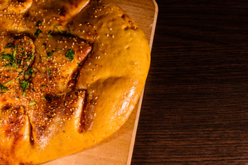 Pita bread with garlic on a wooden cutting board. Top view