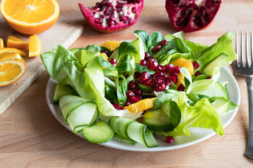 Vegetable salad with orange slices and pomegranate seeds