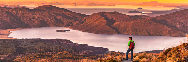Reizen wandelen man kijken naar natuur landschap zonsondergang panoramisch banner achtergrond. Avontuurlijke reiziger in openlucht Nieuw-Zeeland, backpackende wandelaar. Ruimtepanorama kopiëren.