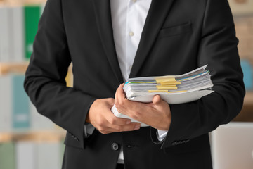 Young man with documents in office