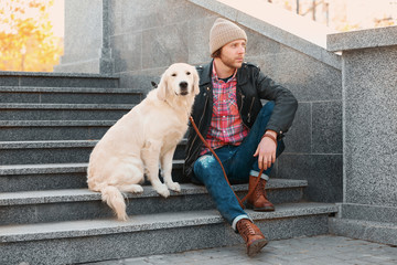 Handsome young hipster with dog outdoors